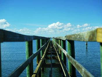 Bridge over calm blue sea against sky