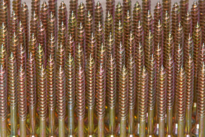 Full frame of yellow screws side by side