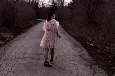 Full length of woman standing on footpath