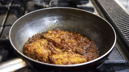 Preparation of meat stew with cooking pan on the stove, italy