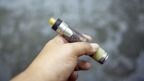 Close-up of hand holding cigarette