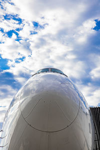 Cockpit of jet airplane against blue cloudy skies