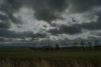 Scenic view of field against cloudy sky