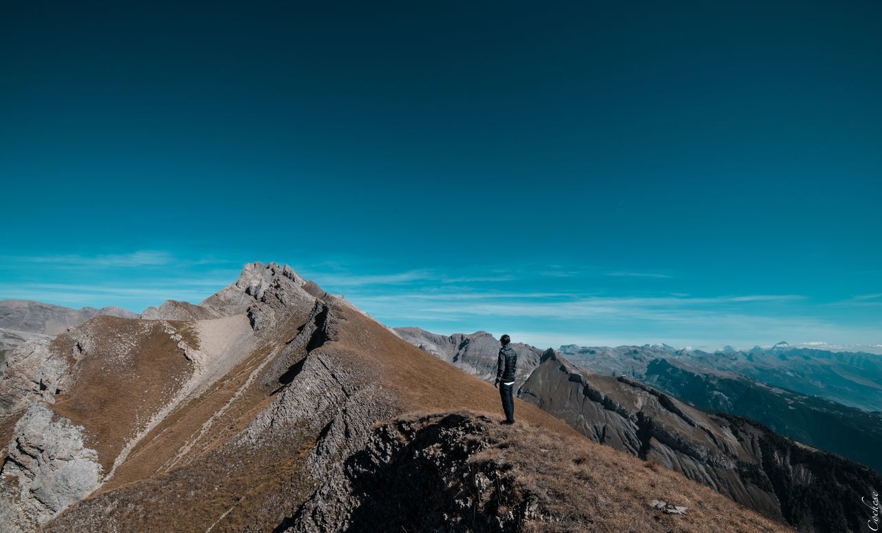 sky, scenics - nature, beauty in nature, mountain, tranquil scene, blue, tranquility, nature, non-urban scene, copy space, environment, day, no people, landscape, mountain range, idyllic, remote, cloud - sky, rock, outdoors, mountain peak