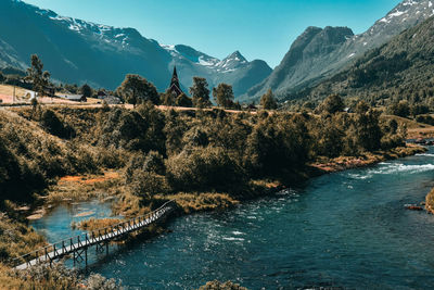 Scenic view of river by mountains against sky