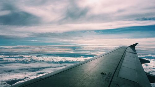 Close-up of airplane wing against sky during sunset