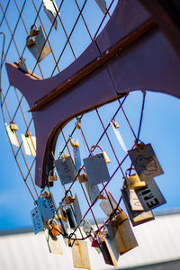 Low angle view of lighting equipment hanging against sky
