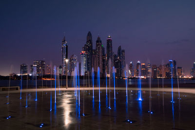 Illuminated buildings against sky at night