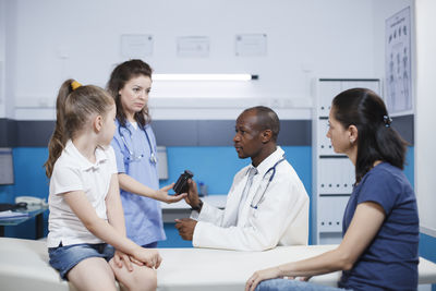 Female doctor examining patient in office