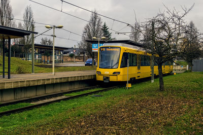 Train on railroad track amidst field against sky