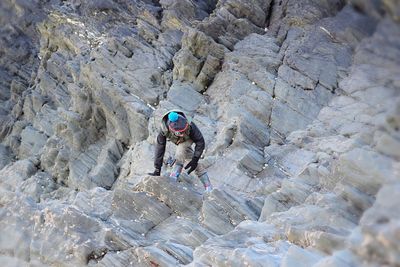 High angle view of person climbing on rock