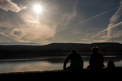 A couple are resting near a lake in logroño.