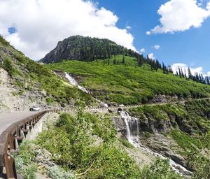 Scenic view of river by mountains against sky