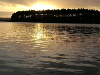 Scenic view of lake against sky at sunset