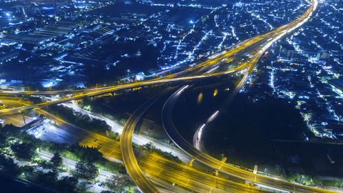 Aerial view of illuminated multiple lane highway in city at night