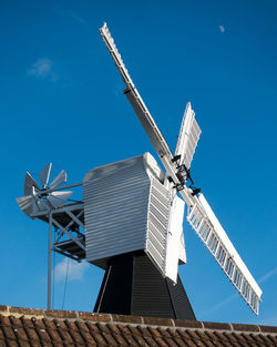 Low angle view of windmill against clear blue sky