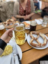 Midsection of woman holding drink on table