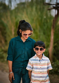 Mother and son wearing sunglasses standing outdoors