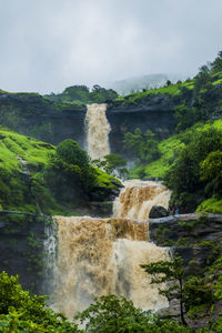 Scenic view of waterfall against sky