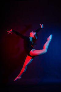 Low section of woman standing against black background