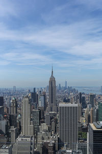 Modern buildings in city against cloudy sky