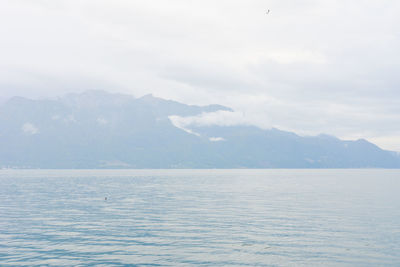 Scenic view of sea and mountains against sky