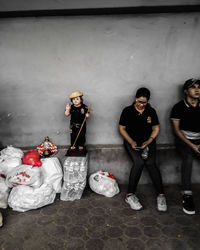 Portrait of young couple standing against wall