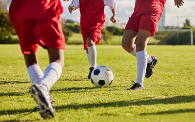 Low section of man playing soccer on field