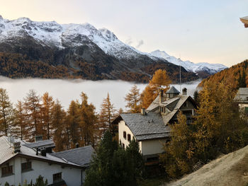 Houses on snowcapped mountains against sky