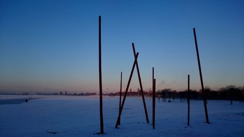 Scenic view of snowy field against clear sky during sunset