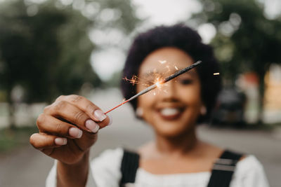 Close-up of woman hand holding lit sparkler