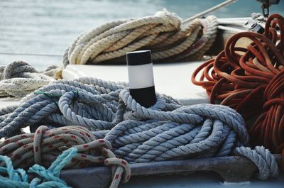 Close-up of rope tied to bollard at harbor