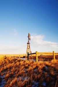 Traditional windmill on field against clear sky