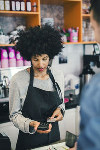 Young woman using smart phone at store