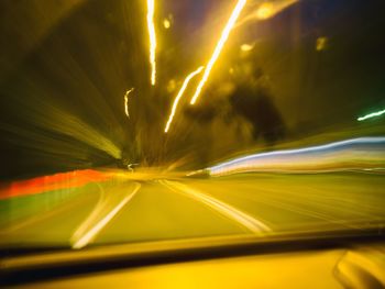 Light trails on road against sky at night