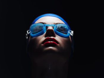 Portrait of man wearing mask against black background