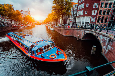 Tour boat at famous dutch canal on sunset evening. amsterdam holland