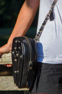 Midsection of man holding hands while standing outdoors