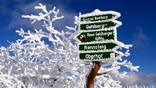 Low angle view of information sign against blue sky