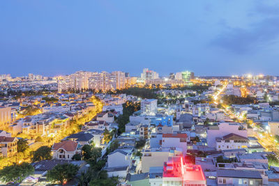 High angle view of illuminated cityscape against sky at dusk