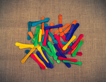 Directly above shot of colorful popsicle sticks on burlap