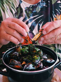 Midsection of person eating mussel
