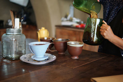 Close-up of hand holding tea cup on table in restaurant