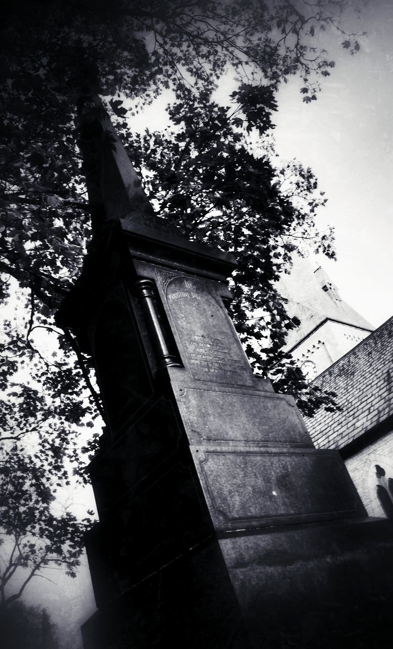 building exterior, low angle view, tree, built structure, architecture, statue, human representation, branch, sculpture, religion, day, auto post production filter, outdoors, sky, no people, art and craft, shadow, sunlight, spirituality