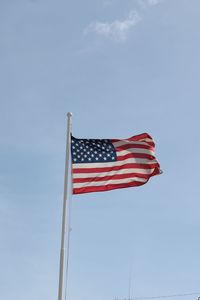 Low angle view of flag against blue sky