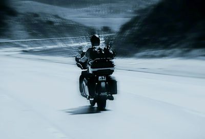 Rear view of man riding bicycle on mountain