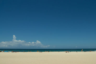 Scenic view of beach against blue sky