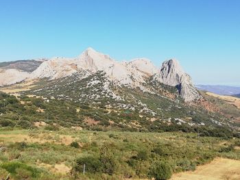 Scenic view of rocky mountains against clear blue sky