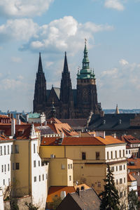 Buildings in city against cloudy sky