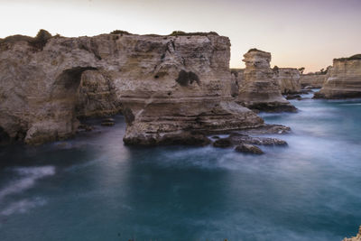 Natural arch at melendugno against clear sky at dusk